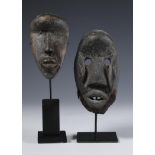 Liberia, a Dan and a Kran wooden hand masks, the second item with human hair goatee, both on stand