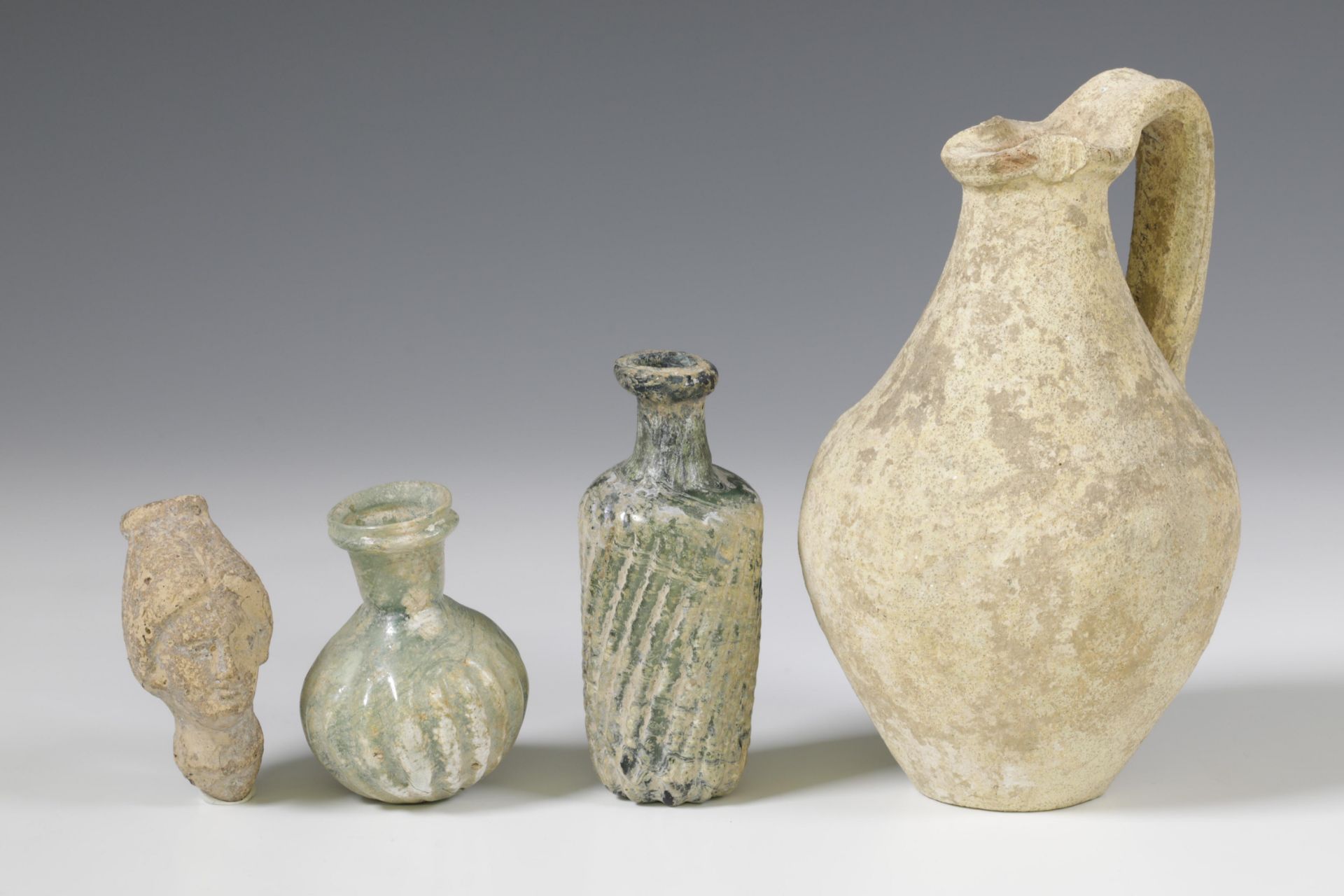 Two Roman glass bottles and a terracotta flask, 2nd-3rd century.