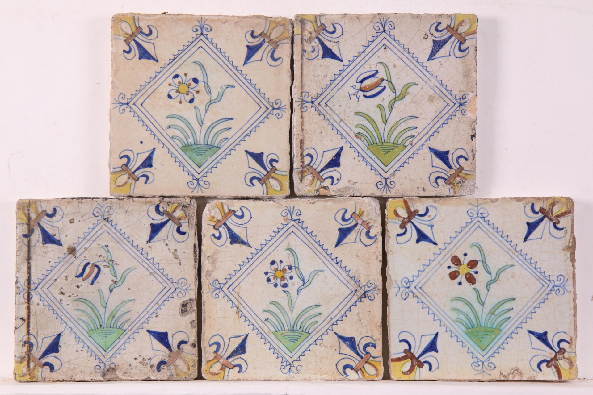 Vijf polychroom aardewerk bloemendecor tegel in gekarteld kwadraat, ca. 1620 - 1650;