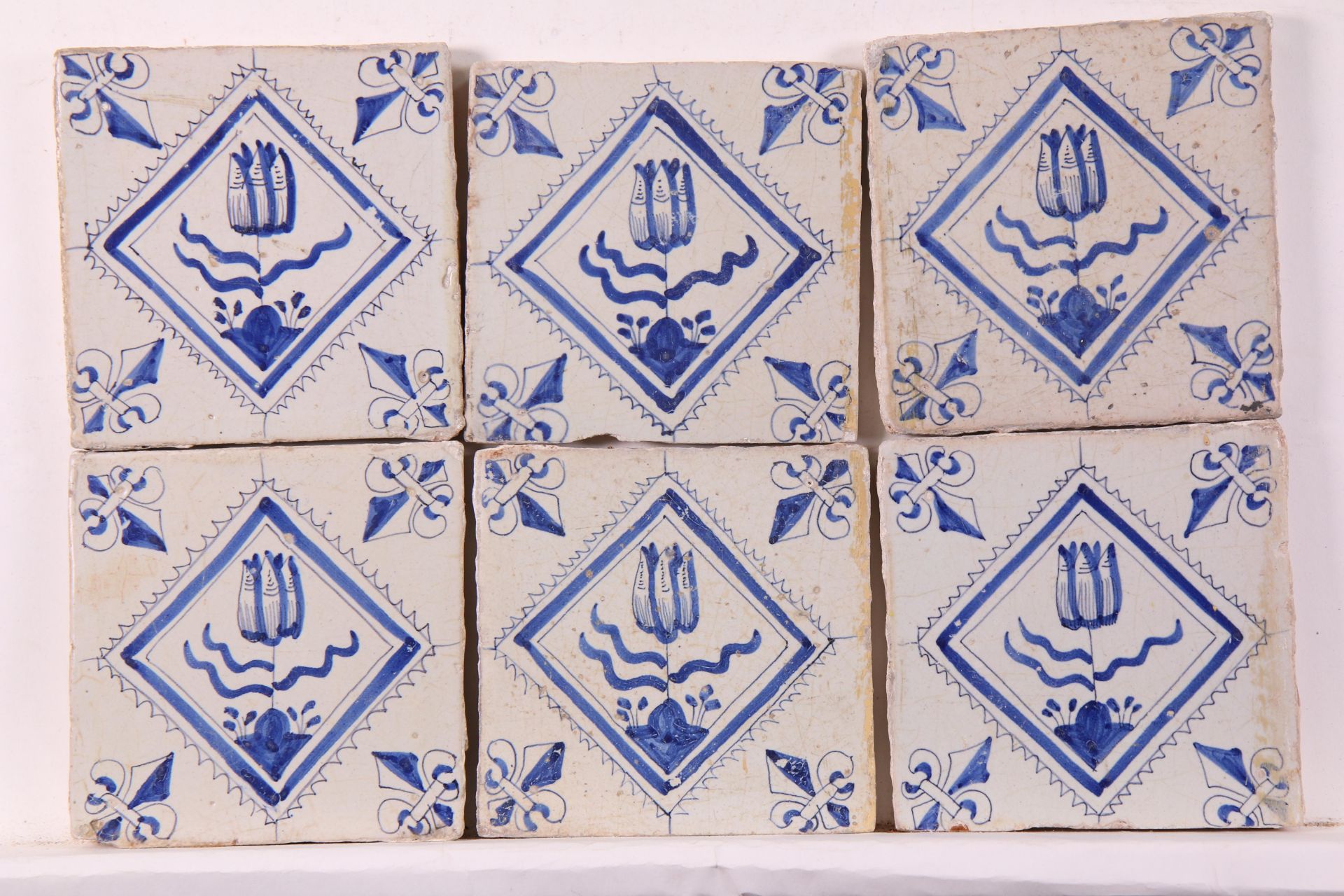 Zes blauwe aardewerk bloemendecor in gekarteld kwadraat tegel, ca. 1620-1650;