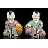 2 porcelain statues of seated figures with flowers