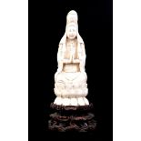 Richly carved ivory Quanyin sitting on a throne of lotus flowers, on a loose wooden base. China appr