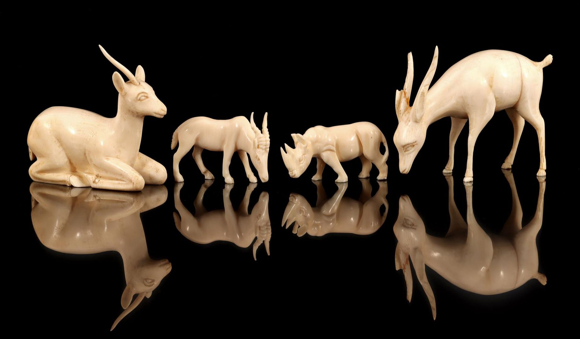 4 richly carved ivory animals including rhinoceros, Africa ca.1920, 3.5 to 7 cm high, together 215.4