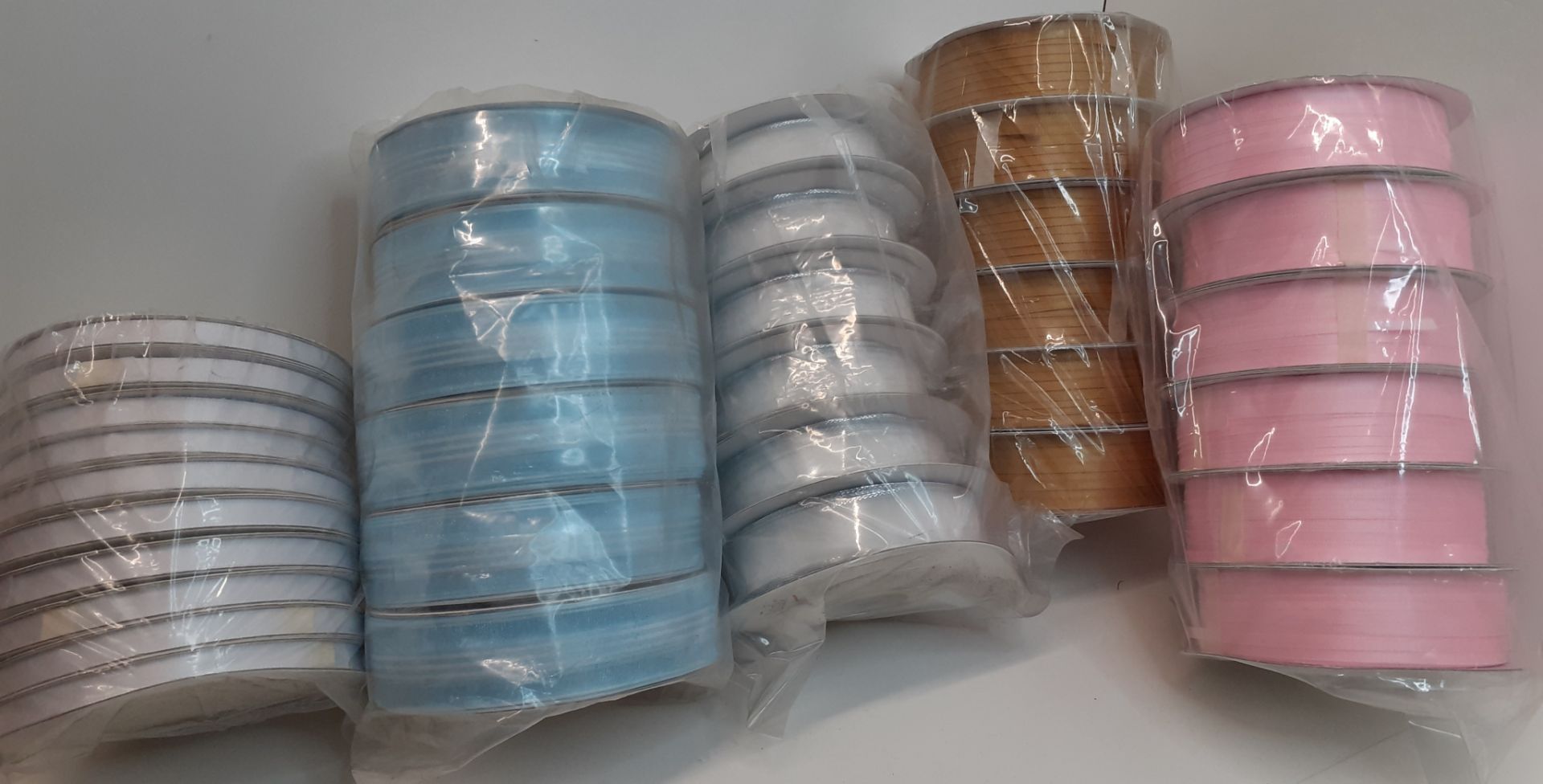 X 120 BRAND NEW ROLLS OF RIBBONS IN FIVE DIFFERENT COLOURS, SHAPE AND DESIGN.