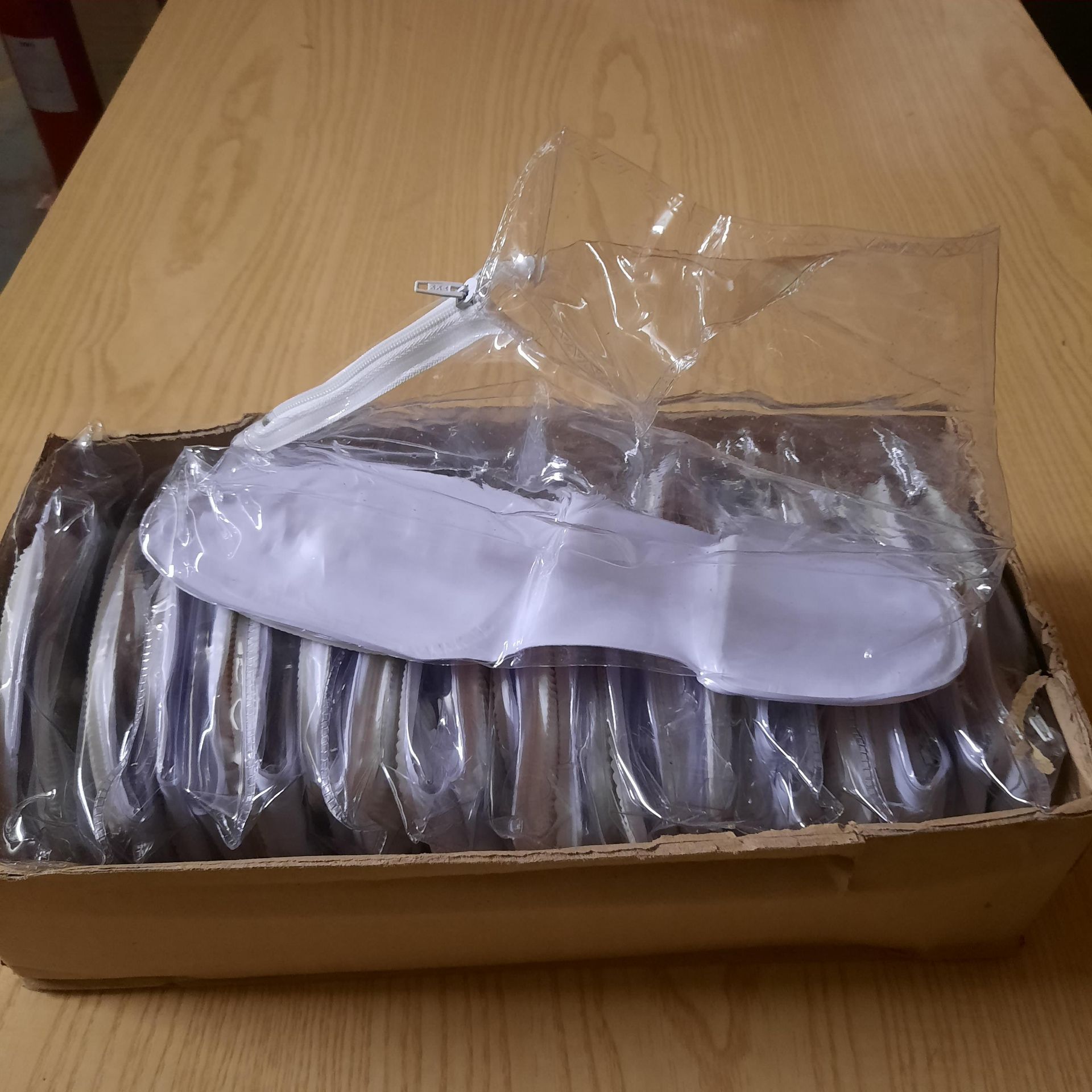 X 12 BRAND NEW PAIRS OF CLEAR PLASTIC SHOES WITH ZIP AND INDIVIDUALLY PACKAGED.