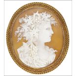 A Victorian gold mounted oval shell cameo brooch, finely carved to depict a bacchante with cascading