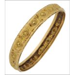A decorative bangle, the yellow precious metal bangle with repeating stamped roundel decoration, the