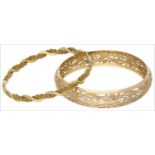 Two yellow precious metal bangles, the first concave in profile with pierced scrolling foliate