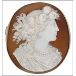 A Victorian oval shell cameo brooch, carved to depict a female in profile, with ringlets and flowers