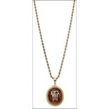 A Victorian gold mounted carnelian pendant, the cabochon carnelian with applied gold monogram, the