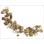 A charm bracelet, the fetter-link bracelet suspending 34 charms, mostly 9ct gold, including a 9ct