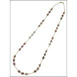 A garnet set necklace, the oval mixed-cut garnets spectacle set in trios, between fine curb-link