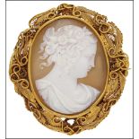 An oval shell cameo brooch, carved to depict a classical female profile, with sprays of flowers in