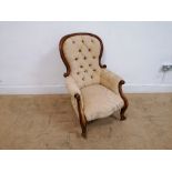 A Victorian mahogany framed button back arm chair having padded back support and seat raised on