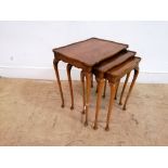 A nest of three walnut veneer tables having a pie crust top, raised on cabriole legs.