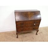 An early 20th century mahogany bureau having a fall front top over three graduating long drawers