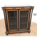 A 19th century satinwood and ebony credenza having a moulded top over panel glazed doors enclosing