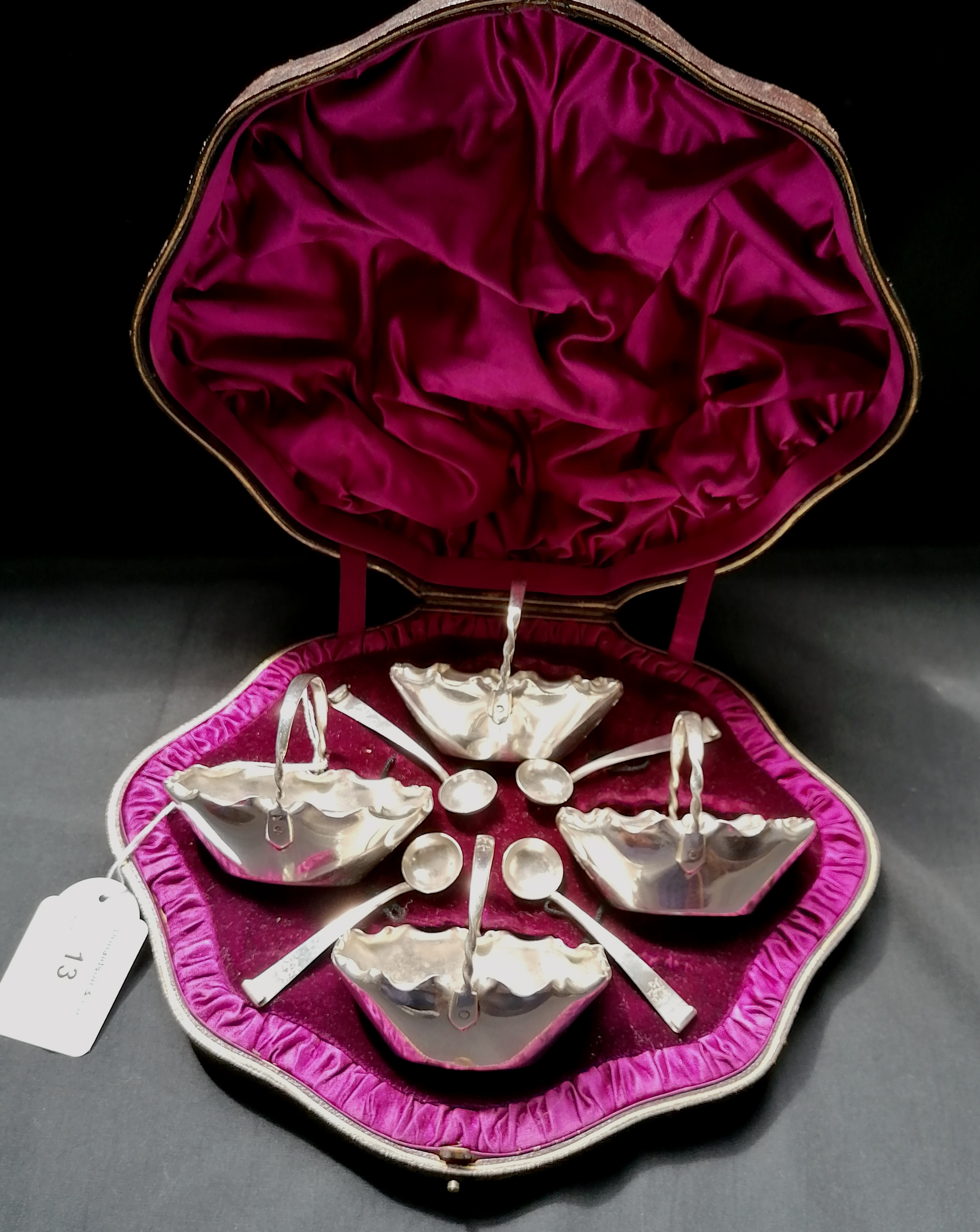 Cased set of four Victorian silver salts and spoons in the dimpled style of handled baskets with