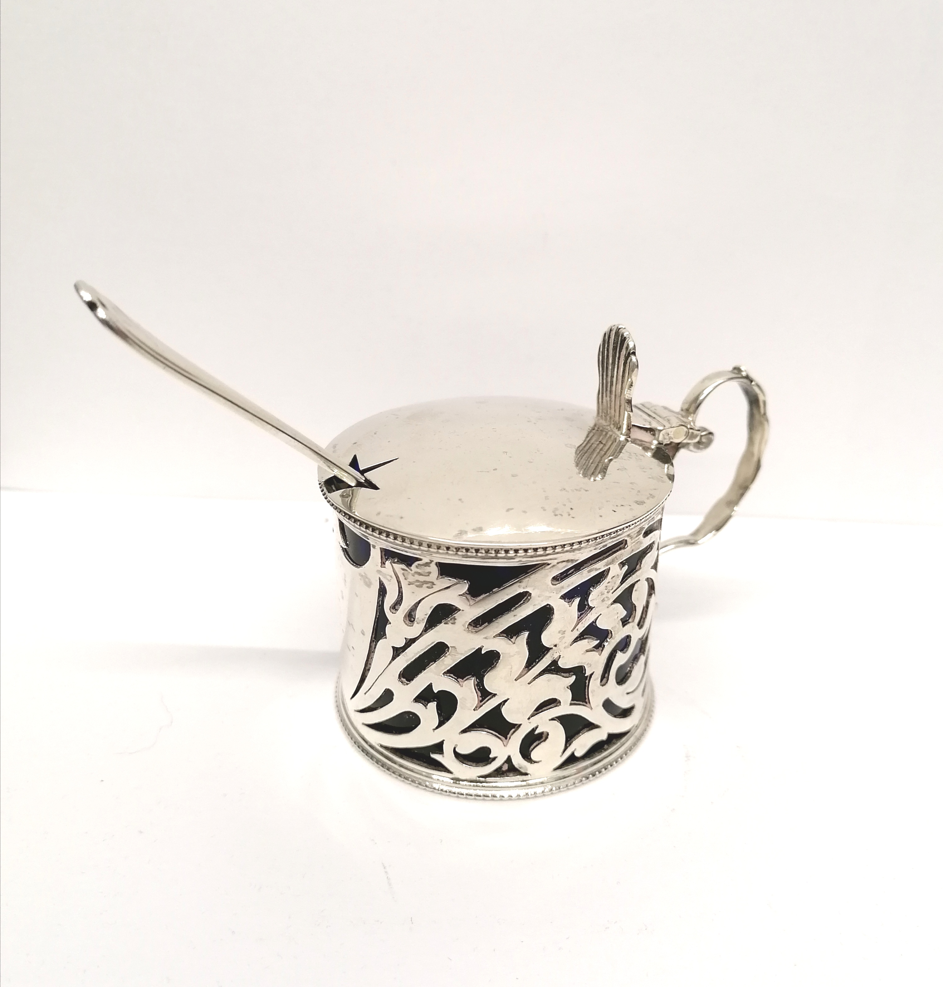 A Birmingham silver mustard dated 1909 complete with blue liner and a silver spoon. 6 cm height, 8