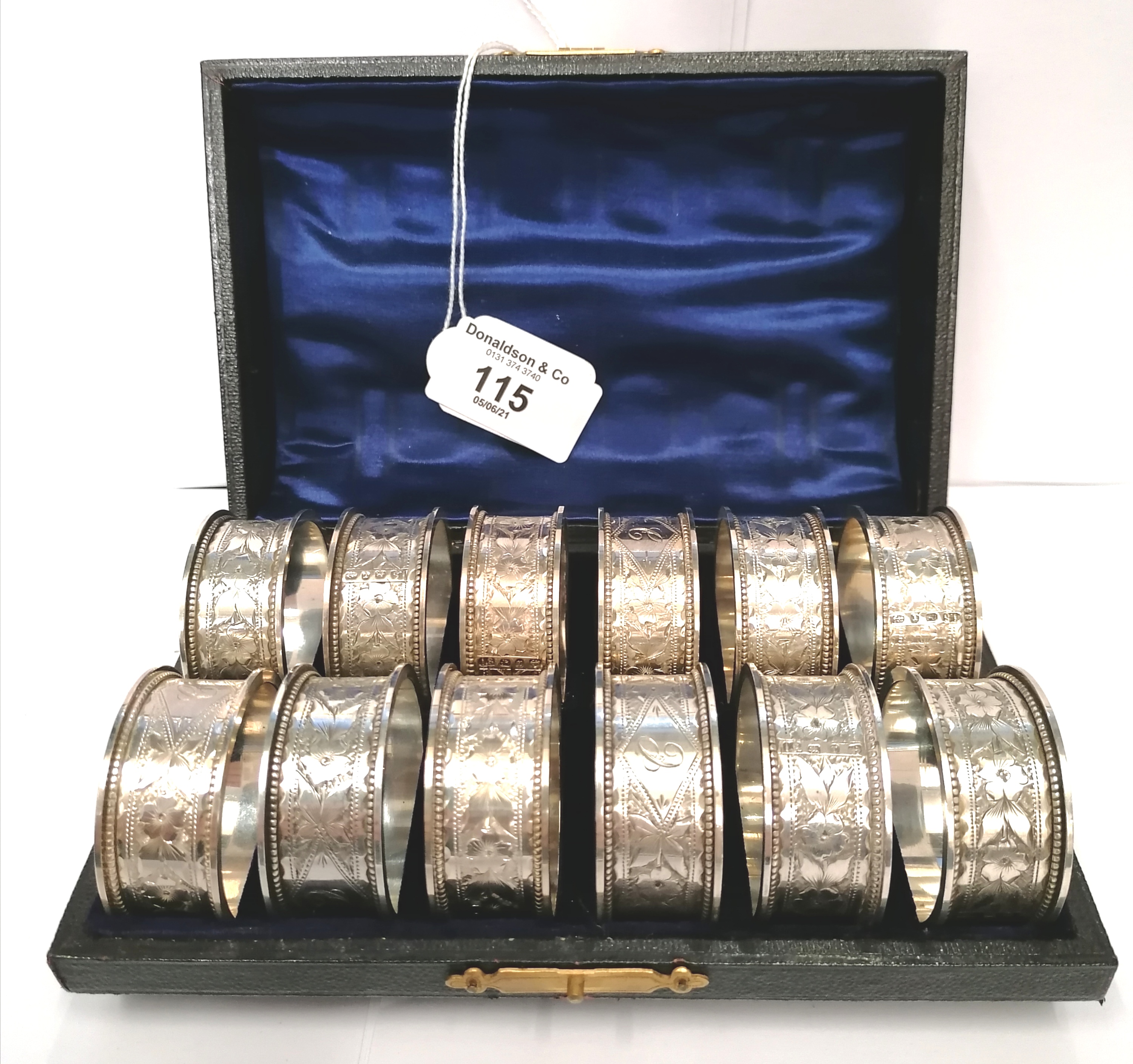 Fine cased set of twelve silver napkin rings decorated with floral chasing and miniature gadroon