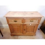 A late Victorian pine dresser having moulded top over two short drawers above cupboard. Raised on