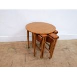 Mid century teak nest of four tables in circular form. 56 cm width, 57 cm height.