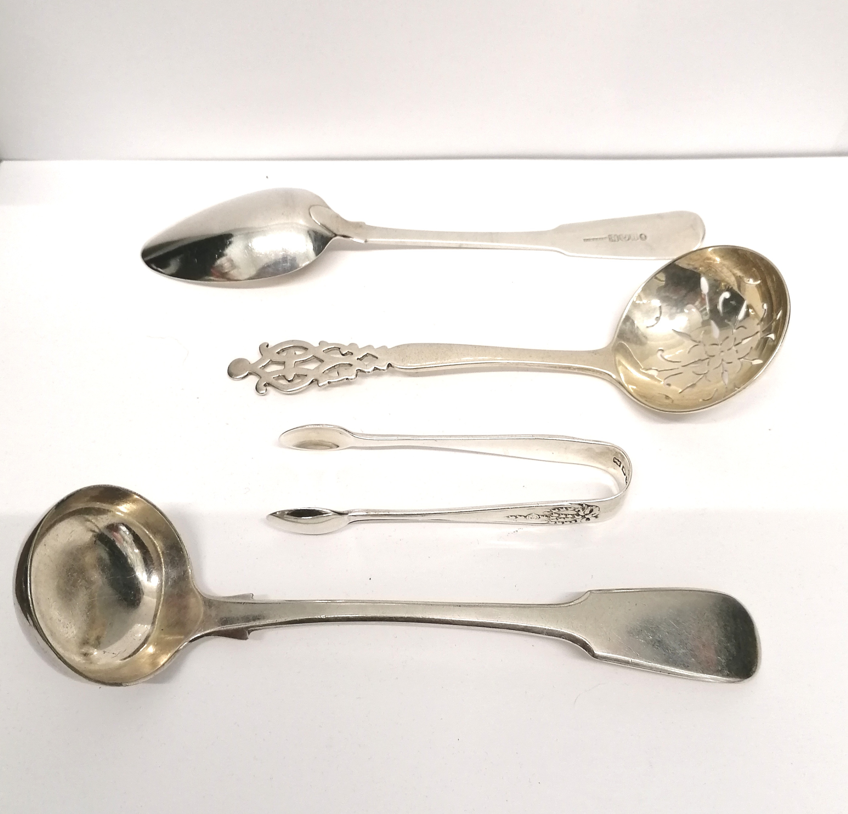 A London silver tea strainer dated 1911 together with a pair of London silver sugar nips, an