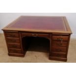 A 19th century desk of large proportions having an inset red skiver top over one long drawer and