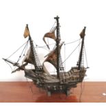 A model three mast sailing ship on stand.