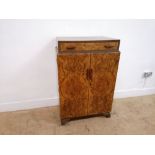 1930 Burr walnut linen press having long drawer to top over two panel doors enclosing two short