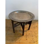 PERSIAN SILVERED COPPER CIRCULAR TRAY ON FOLDING STAND CIRCA 190054cm high, 75cm dia