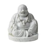 BLANC DE CHINE FIGURE OF A LAUGHING BUDDHA QING DYNASTY modelled seated wearing a long flowering
