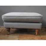 CONTEMPORARY UPOHOLSTERED FOOT STOOL ON TURNED LEGS WITH BRASS CASTORS (73cm long, 44cm wide, 42cm