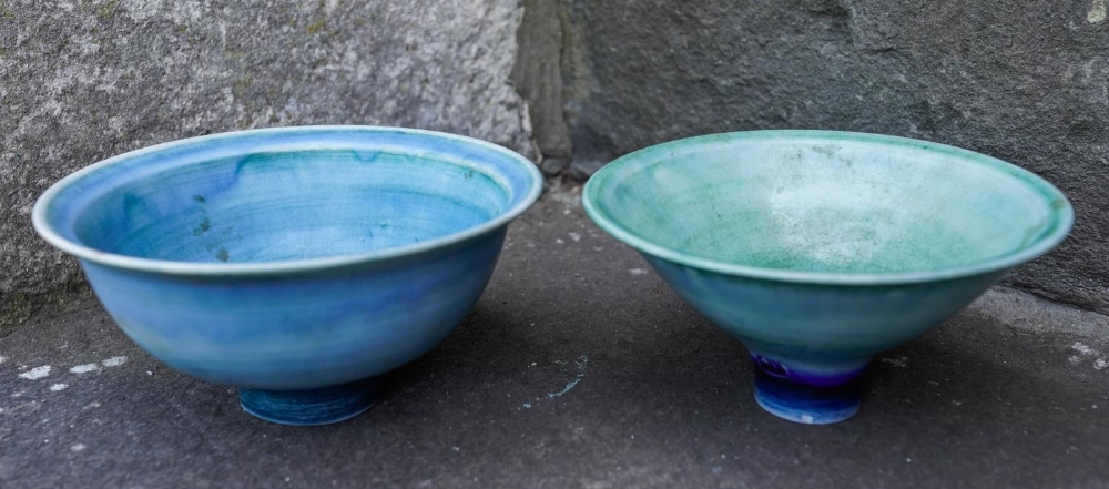 MARY RICH (b. 1940) TWO FOOTED BOWLS each covered in a rich mottled blue / green glaze, impressed ma