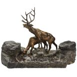 A CONTINENTAL STONE INKSTAND CIRCA 1900 the rough hewn marble base surmounted by two bronze deer