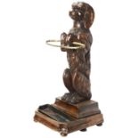 A GOOD 19TH CENTURY BLACK FOREST BRASS-MOUNTED LINDEN WOOD STICK STAND in the form of a begging