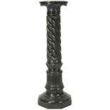 A VICTORIAN SERPENTINE COLUMN with spiral carved decoration upon a circular base with octagonal