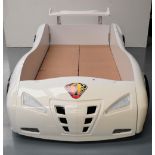 AN 'EXTRA TURBO POWER' CHILDS NOVELTY BED IN THE FORM OF A RACING CAR. 72 x 118 x 230 cms
