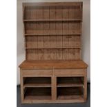 A STRIPPED PINE DRESSER with tall, stepped plate rack back, old base with later additions and
