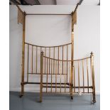 AN EDWARDIAN BRASS TESTER BED, the square section frame with curved end rails, the head with two