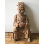 A CHINESE CARVED WOOD FIGURE OF AN OFFICIAL, LATE MING, EARL QING, with traces of old lacquer and