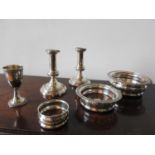 A PAIR OF SILVER PLATE CANDLESTICKS AND TWO SILVER PLATE DECANTER COASTERS, with smaller coaster and