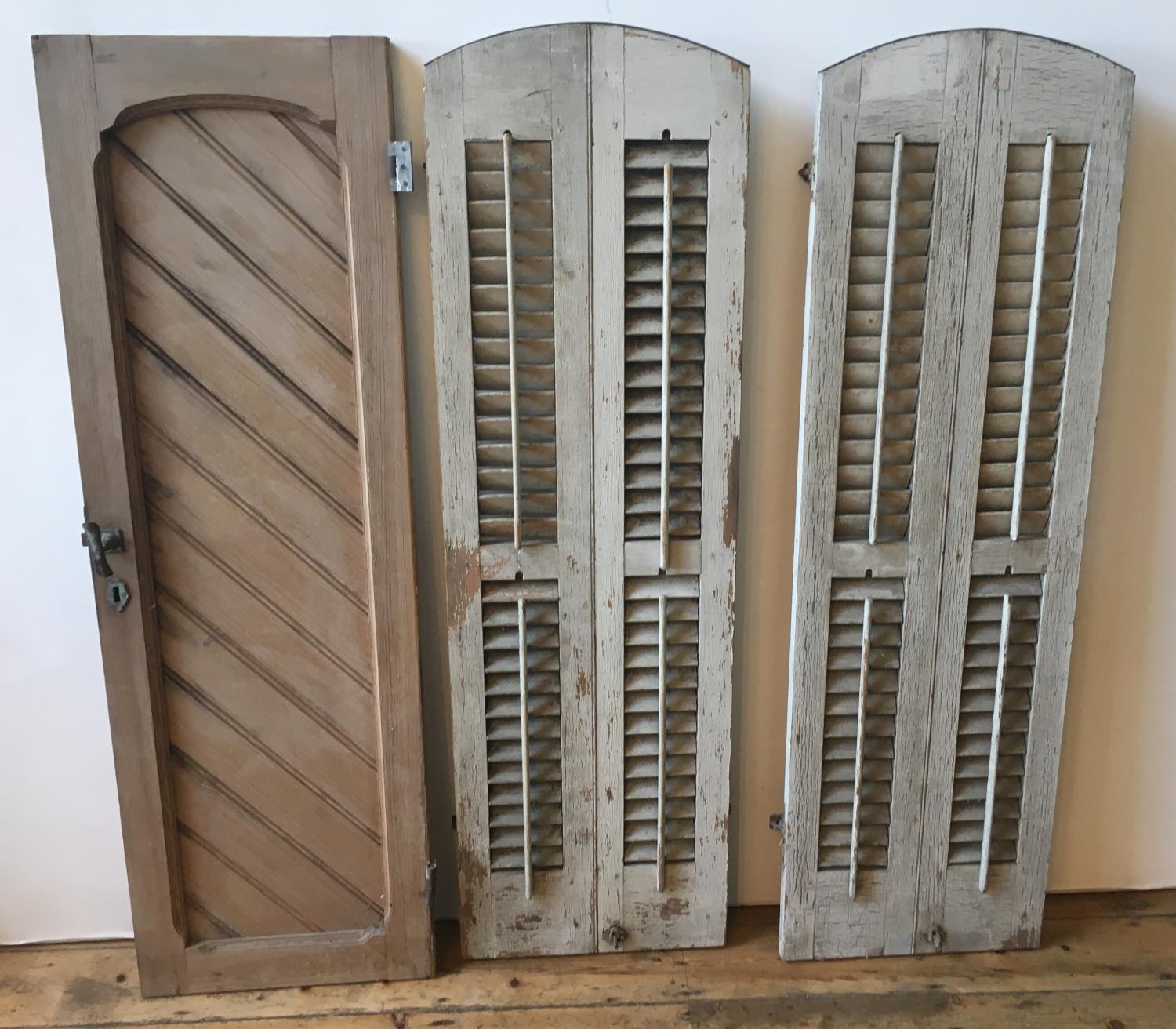 A PAIR OF CREAM PAINTED DISTRESSED WINDOW SHUTTERS (150 x 46cms) AND A PINE WINDOW SHUTTER (149 x