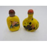 TWO 20th CENTURY YELLOW GLASS SNUFF BOTTLES, one with embossed grasshopper decoration, and the other