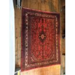 AN IRANIAN RED AND BLUE HAND KNOTTED HAMADAN RUG, 280 x 215cm