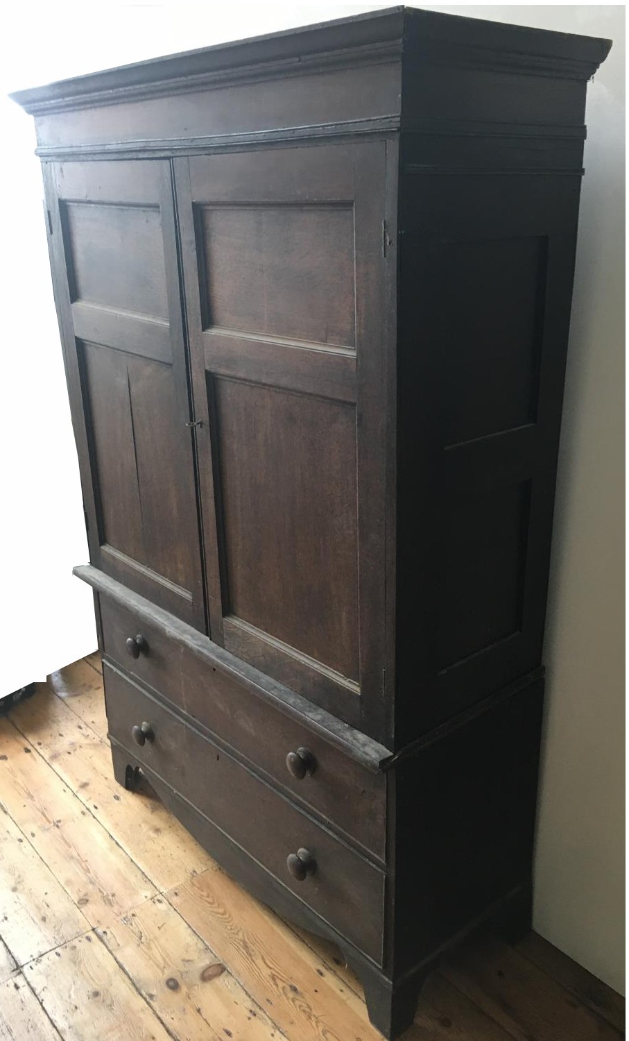 A 19th CENTURY TWO DOOR PANELLED CUPBOARD ON A CHEST OF TWO LONG DRAWERS