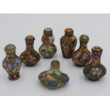 SEVEN CHINESE CLOISONNE SNUFF BOTTLES 20TH CENTURY each with a stained wood stand 7cm high (
