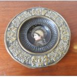 ORNATE EMBOSSED BRASS WALL PLAQUE WITH CERAMIC PORTRAIT PANEL INSIDE, 29cm dia, the border