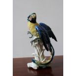 A KARL ENS CERAMIC FIGURE OF PARROT ON LEAFY PERCH, 32.5cm high