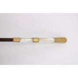 A 19th WALKING CANE WITH A MOTHER OF PEARL AND YELLOW METAL HANDLE, the yellow metal banding and